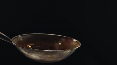 Şef rafadan erişte pişiriyor, tavada karides kızartıyor, taze sebze ekliyor ve siyah arka planda malzemeleri karıştırıyor. Asya yemeği, mutfağı, restoranı, tadı, yemeği, tarifi