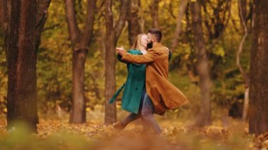 Mutlu bir aile. Yakışıklı bir adam ve güzel bir kadın. Ormanda güzel vakit geçiren bir çift. Sıcak bir sonbahar gününde park edip dans ediyorlar. Sonbahar mevsimi kavramı, ilişki, hafta sonu aktivitesi, doğa keyfi