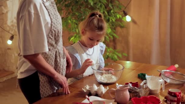 有爱心 有爱心的女人 妈妈和她的小女儿一起做饭 教孩子们烘焙 教女孩为饼干做面团 教她们煎蛋 饼干日 家庭的概念 — 图库视频影像