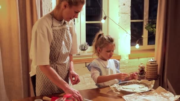 妈妈和小女儿在家做饭做圣诞饼干舒适的夜晚在家里 把面团放进烤盘里 饼干日 家庭的概念 — 图库视频影像
