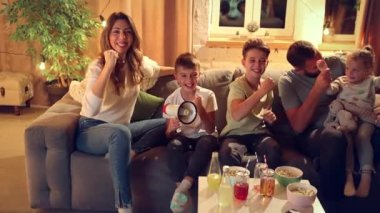 Aile, aileler ve çocuklar akşamları kanepede oturup futbol maçı çevirisini izliyorlar. Kazanan gol. Aile kavramı, boş zaman, rahatlama, çocukluk ve ebeveynlik