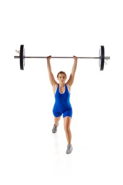 Rekabet. Spor giyimli, beyaz arka planda ağır halterleri kaldıran bir kadın. Spor anlayışı, güç, spor, sağlıklı yaşam tarzı, güç ve dayanıklılık, halter.