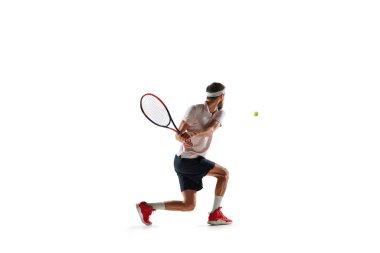 Spor kıyafetleriyle tenis oynayan, beyaz arka planda izole edilmiş raketle koşan genç bir adamın dinamik görüntüsü. Spor anlayışı, hobi, aktif ve sağlıklı yaşam tarzı, rekabet