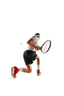 Motive olmuş bir sporcu, maç sırasında tenis oyuncusu, raketle hareket eden, beyaz arka planda izole bir şekilde oynayan. Spor anlayışı, hobi, aktif ve sağlıklı yaşam tarzı, rekabet