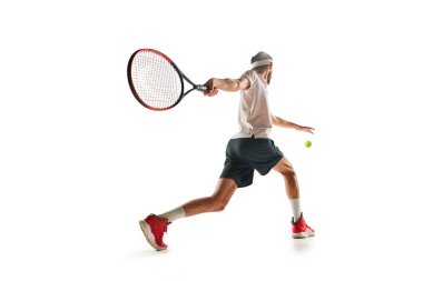 Spor kıyafetleriyle tenis oynayan, beyaz arka planda izole edilmiş raketle koşan genç bir adamın dinamik görüntüsü. Spor anlayışı, hobi, aktif ve sağlıklı yaşam tarzı, rekabet
