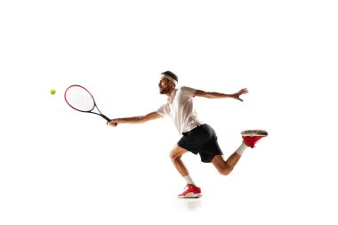Rekabetçi bir adam, hareket halinde tenis oyuncusu, raketle topa vuruyor, beyaz arka planda soyutlanmış bir şekilde oynuyor. Spor anlayışı, hobi, aktif ve sağlıklı yaşam tarzı, rekabet