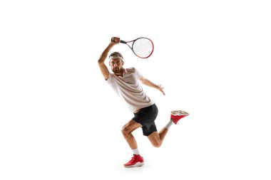 Yoğunlaşmış genç adamın dinamik görüntüsü, tenisçi pratik yapıyor, oynuyor, beyaz arka planda izole edilmiş raketle topa vuruyor. Spor anlayışı, hobi, aktif ve sağlıklı yaşam tarzı, rekabet