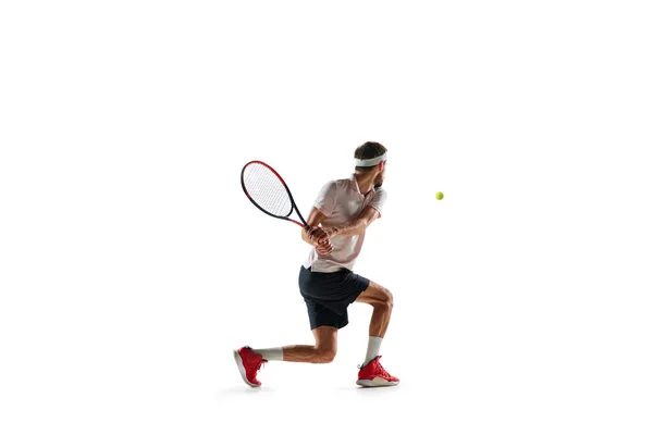 スポーツウェアの若者のダイナミックなイメージ テニスを練習し 白い背景の上に隔離されたラケットで実行 スポーツ アクティブで健康的なライフスタイル コンテスト — ストック写真