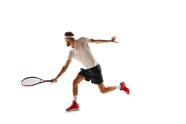 濃縮された若者 テニス選手のダイナミックなイメージ 白い背景の上に隔離されたラケットでボールを打つ スポーツ アクティブで健康的なライフスタイル コンテスト — ストック写真