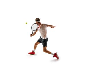 Konsantre bir adam, oyuncu sırasında hareket eden bir tenis atleti, beyaz arka planda izole edilmiş raketle antrenman yapıyor, oynuyor, topa vuruyor. Spor, hobi, aktif ve sağlıklı yaşam tarzı, rekabet konsepti