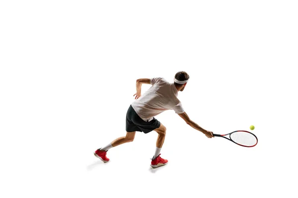 濃縮された若者 テニス選手のダイナミックなイメージ 白い背景の上に隔離されたラケットでボールを打つ スポーツ アクティブで健康的なライフスタイル コンテスト — ストック写真