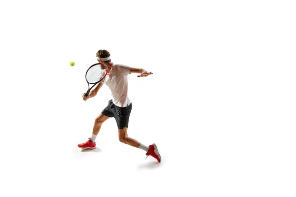 ゲーマー 白い背景に隔離されたラケットでボールを打つ間に運動中の集中した男 テニス選手 スポーツ アクティブで健康的なライフスタイル コンテストのコンセプト — ストック写真