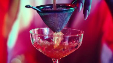 Genç kız, barmen çelik karıştırıcıdan kokteyl dolduruyor. Neon barda nefis kokteyller yapıyorum. Meslek kavramı, gece hayatı, bar, parti, alkol içeceği, mixolog