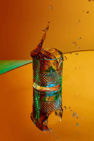 Ice Cube Falling Glass Strong Drink Whiskey Coke Orange Background — Stock Photo, Image