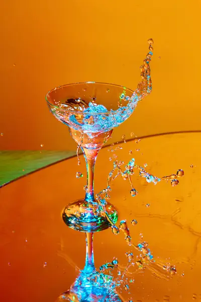 Ijsblokje Valt Glas Met Martini Cocktail Tegen Oranje Achtergrond Neon — Stockfoto