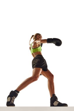 Kaslı genç bir kadın, hareketli boks sporcusu, eğitimli, beyaz arka planda izole edilmiş yumruklar. Spor anlayışı, aktif ve sağlıklı yaşam tarzı, güç ve dayanıklılık, vücut bakımı