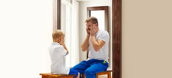 Little boy, child sitting and looking in mirror at reflection of future him. Being adult. Conceptual collage. Concept of present, past and future, age, life cycle, generation, ad