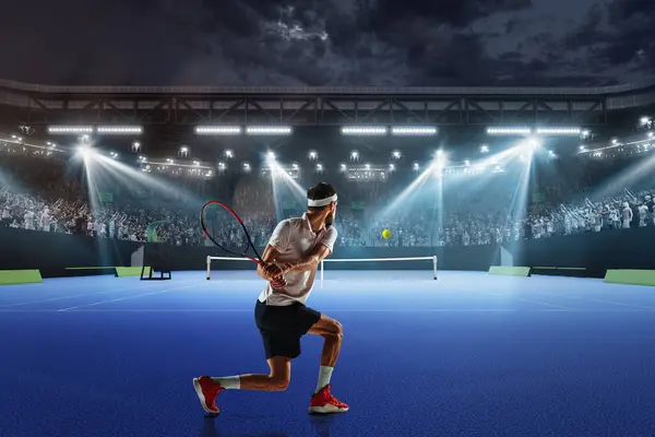 Concentrated young man, tennis athlete in motion on tennis court, playing, hitting ball with racket. Fans cheering up player. Concept of sport, competition, tournament, action, success