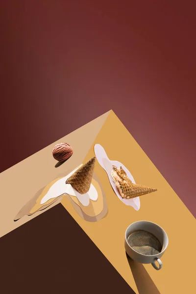 Coffee cup with spilling coffee and melting ice cream in waffle cone over brown background. Creative collage. Surrealism. Concept of creativity, abstract art, minimalism, food