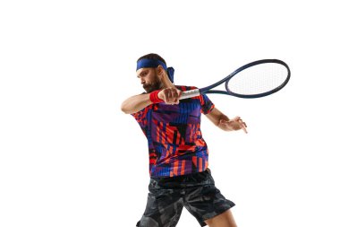 Konsantre sakallı genç adam, tenis oyuncusu raketle topa vuruyor, beyaz arka planda soyutlanmış bir şekilde oynuyor. Profesyonel spor, hareket, rekabet, eylem kavramı. Ad