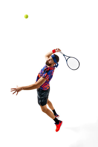 Full-length dynamic image of young man, tennis player in bright sportswear in motioned during game, hitting ball isolated over white background. Concept of professional sport, competition, action. Ad