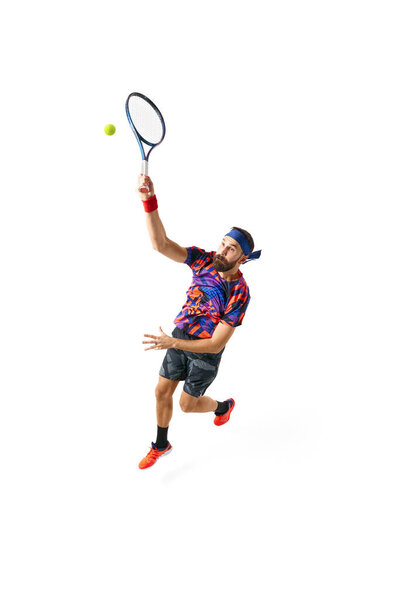 Full-length dynamic image of young man, tennis player in bright sportswear in motioned during game, hitting ball isolated over white background. Concept of professional sport, competition, action. Ad