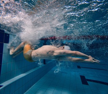 Hız ve dayanıklılık. Genç adam, profesyonel yüzme sporcusu, antrenman, havuzda yüzme. Havuz sporları, su sporları, rekabet, aktif yaşam tarzı kavramı
