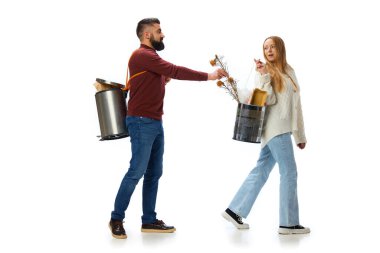 Adam kuru çiçekleri çöp kutusuna koyuyor. Genç insanlar, erkek ve kadın gezegenden gezegene bakıyorlar, temizliği beyaz arka planda yapıyorlar. Çevre, ekoloji, doğa bakımı, geri dönüşüm, farkındalık kavramı