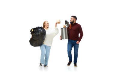 Çevre temizliği yapan genç erkek ve kadın çöpleri alıp götürüyor. Çevre kavramı, ekoloji, doğa bakımı, geri dönüşüm, farkındalık.