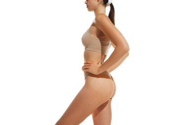 İnce kesilmiş görüntü. Kadın vücuduna uygun, kalçaları iç çamaşırlarıyla beyaz arka planda. Anti-selülit masajı, dikkat. Doğal güzellik, sağlık ve vücut bakımı, spor, sağlıklı beslenme, kilo verme kavramı