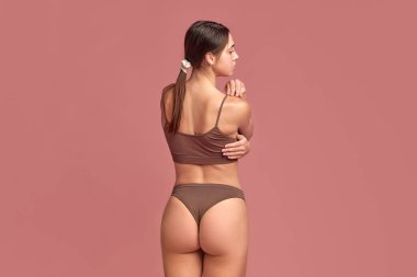 Masaj sırt ağrılarından kurtulmaya yardımcı olur. Arka planda iç çamaşırlı genç bir kızın el ele tutuşup omuz omuza duruşu. Sağlık ve refahı sağlama almak. Güzellik kavramı, vücut bakımı, tıp