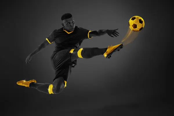 Black and yellow color combination. Young man, football player in motion kicking ball with leg in air. Tournament. Poster for sport events, competition and championship. Energy boost