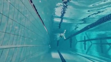 Su altında yüzmek. Mayolu genç bir kız, antrenman yapıyor, havuzda yüzüyor. Hız ve dayanıklılık. Havuz sporları, su sporları, rekabet, aktif yaşam tarzı kavramı