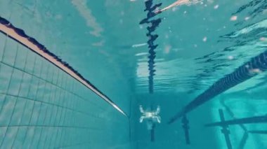 Su altında yüzmek. Mayolu genç bir kız, antrenman yapıyor, havuzda yüzüyor. Hız ve dayanıklılık. Havuz sporları, su sporları, rekabet, aktif yaşam tarzı kavramı