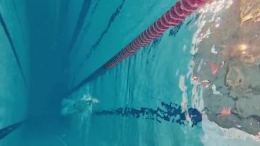 Su altında yüzmek. Mayolu genç bir adam antrenman yapıyor, havuzda yüzüyor. Hız ve dayanıklılık. Havuz sporları, su sporları, rekabet, aktif yaşam tarzı kavramı