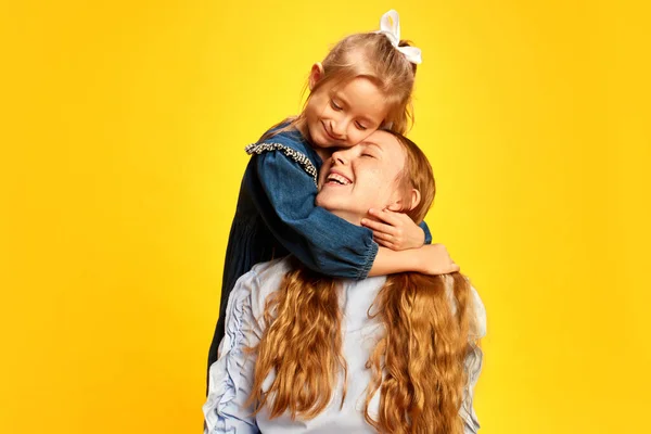 Mała Troskliwa Dziewczynka Dzieciak Przytulający Jej Uśmiechniętą Szczęśliwą Matkę Żółtym — Zdjęcie stockowe
