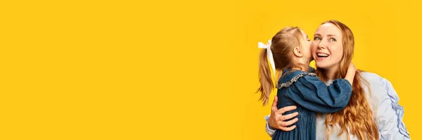Kleines Mädchen Küsst Ihre Glücklich Lächelnde Junge Mutter Vor Gelbem — Stockfoto