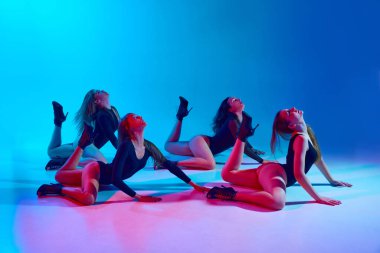 Kadın iktidarı. Vücut kıyafetli, topuklu ayakkabılı, neon ışıkta pembe arka planda dans eden etkileyici tutkulu genç kadınlar. Modern dans stili kavramı, yaratıcılık ve güzellik, sanat, hobi