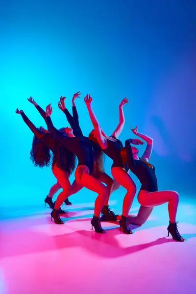 Dance club. Women in black bodysuits dancing passionate modern dance against gradient blue pink background in neon light. Concept of modern dance style, creativity and beauty, art, hobby