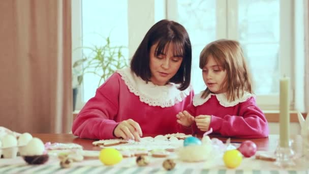家人的目光 年轻的母亲和她的小女儿准备度假 装饰姜饼 家里的面包店假日 复活节 母亲和儿童的概念 — 图库视频影像