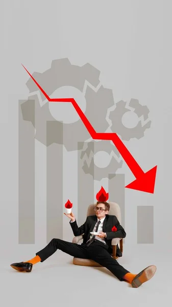 Coping with job loss in declining industry. Conceptual design. Businessman with flames, sitting on fallen chair, downtrend graph, gears backdrop. Concept of economy, crisis, business, challenges