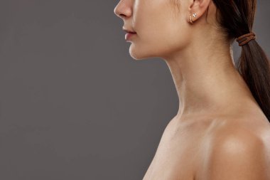 Çift çene. Stüdyonun arka planında kadın yüzü görüntüsü var. Yüz gerdirme, masaj, estetik ameliyat. Doğal güzellik kavramı, kozmetik ve kozmetik, cilt bakımı