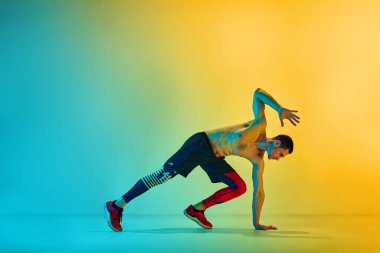 Gücünü ve dayanıklılığını arttır. Kaslı, atletik genç adam, neon ışıkta sarı arka planda eğitime karşı bok gibi çalışıyor. Aktif ve sağlıklı yaşam tarzı kavramı, spor, fitness