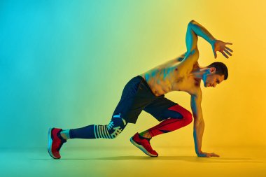 Gücünü ve dayanıklılığını arttır. Kaslı, atletik genç adam, neon ışıkta sarı arka planda eğitime karşı bok gibi çalışıyor. Aktif ve sağlıklı yaşam tarzı kavramı, spor, fitness