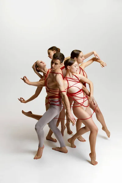 才华横溢的年轻人 男男女女 芭蕾舞演员 用红色的绳子捆绑着 在白色的工作室背景下跳舞 古典舞的概念 现代风格 — 图库照片