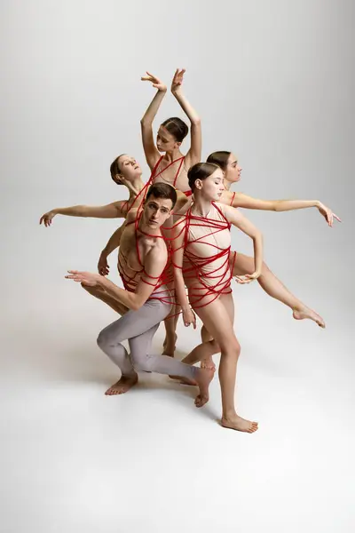 Skupina Baletních Tanečníků Svázaná Červenými Provázky Vytvářející Složitou Pózu Pozadí — Stock fotografie