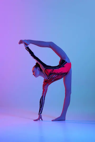灵活的杂技演员 年轻姑娘穿着鲜艳的舞台服装 有节奏的体操运动员在霓虹灯下在渐变工作室的背景下跳舞 美和雅 业余爱好的概念 — 图库照片
