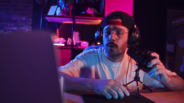 Erkek Şarkıcı Neon Renkli Odada Oturuyor Kulaklıklar Takıyor Şarkı Söylüyor — Stok video