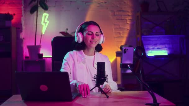 Jovem Mulher Sentada Sala Neon Colorido Fones Ouvido Líder Podcast — Vídeo de Stock