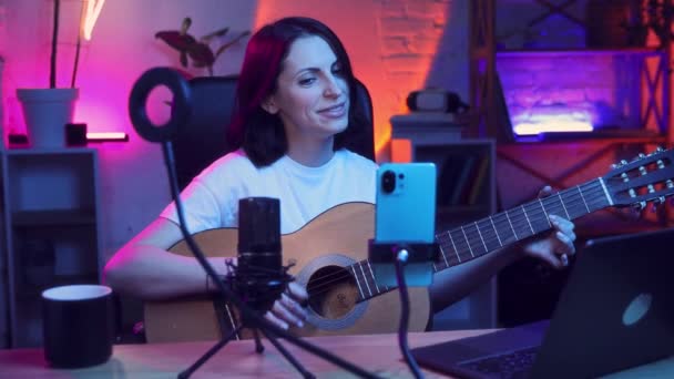 Młoda Kobieta Prowadzi Strumień Wideo Przez Telefon Komórkowy Gra Gitarze — Wideo stockowe